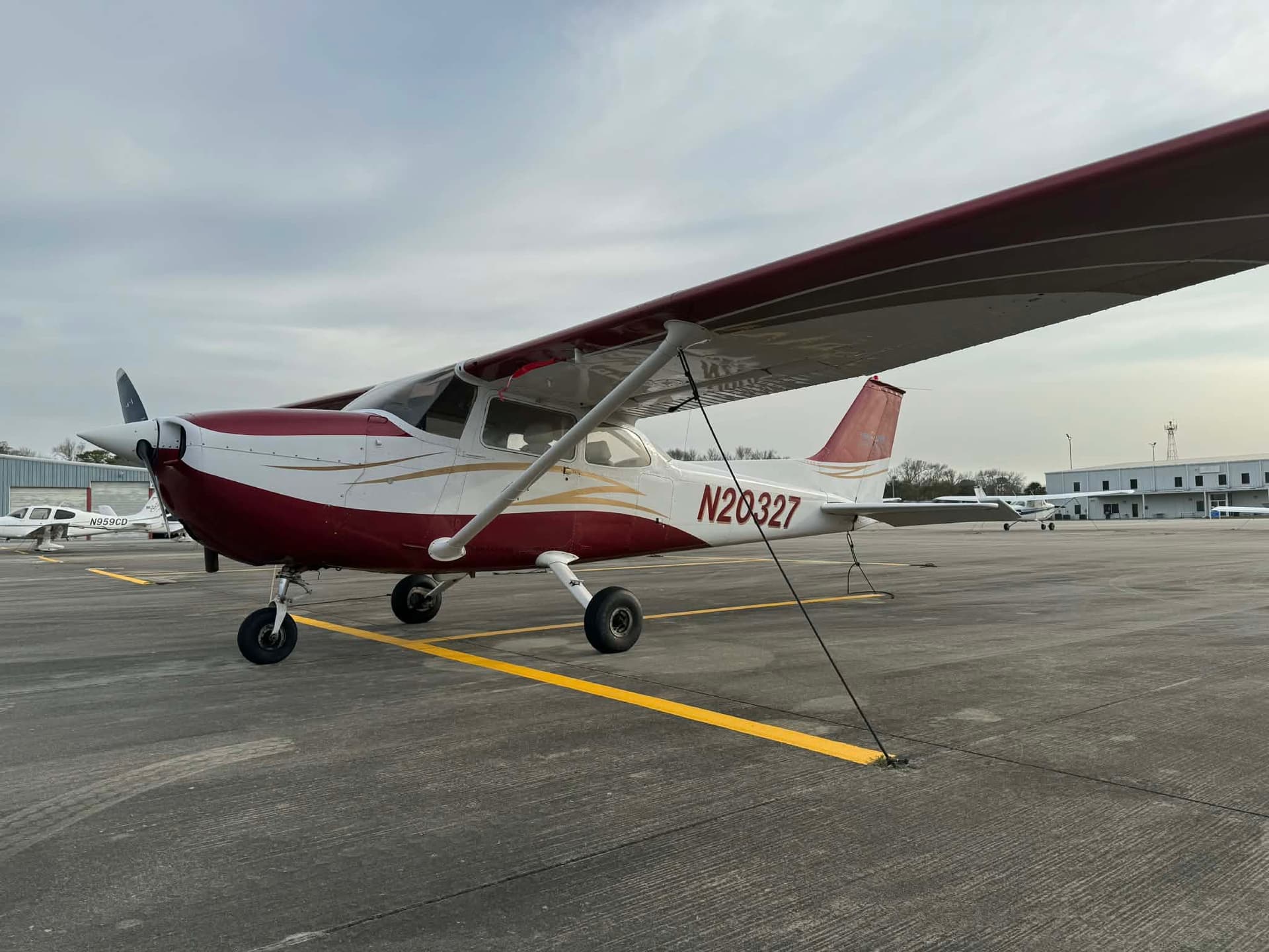 Cessna 172 N20327, white with red trim, parked on the ramp at Grand Strand Airport